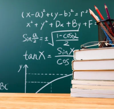 stack-books-with-pencil-holder-glasses-against-chalkboard copy